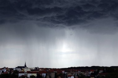 Kasaba üzerinde sağanak yağmur, gök gürültülü bulutlar