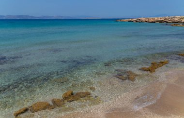 Yunanistan 'ın Saronik körfezinde Akdeniz' in berrak ve mavi sularıyla Aegina adasının kıyıları.