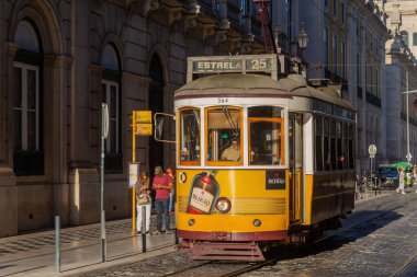 Lisbon, Portugal: Classic traditional yellow trolley tramcar in Lisbon, Portugal. Focus on the driver.