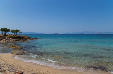 Yunanistan 'ın Saronik körfezinde Akdeniz' in berrak ve mavi sularıyla Aegina adasının kıyıları.