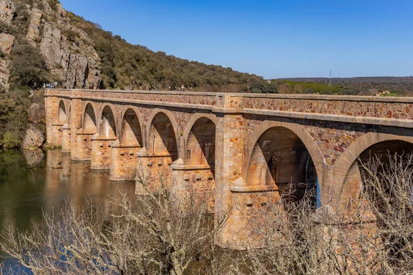 stock image Quintos bridge, is a road bridge inaugurated in 1920, over the river Esla, in the town of Santa Eulalia de Tabara, Municipality of Moreruela de Tabara, province of Zamora, in Spain.