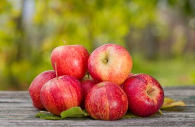 Tahta masadaki birkaç organik kırmızı elmanın yakın çekimi.. 