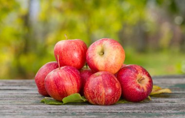 Tahta masadaki birkaç organik kırmızı elmanın yakın çekimi.. 