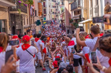 Pamplona, Spain: People celebrate San Fermin festival in traditional white abd red clothing with red necktie, Pamplona, Navarra, Spain.