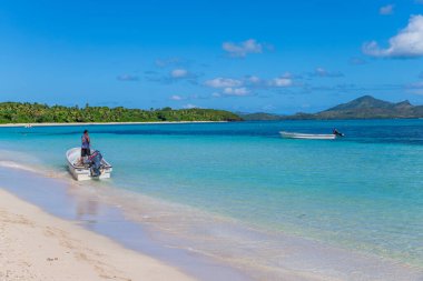 Nacula; Fiji: Sahilde teknede turist bekleyen bir adam, Yasawa Adası 'nda Fiji' de