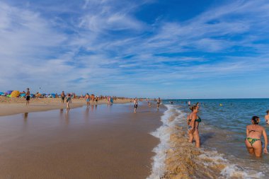 Tavira, Portekiz: Tavira adasının ünlü plajındaki insanlar. Bu plaj Algarve 'nin ünlü turistik bölgesinin bir parçasıdır..