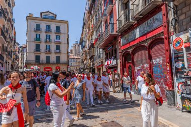 Pamplona, Spain: People celebrate San Fermin festival in traditional white abd red clothing with red necktie, Pamplona, Navarra, Spain.