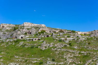 Güney İtalya 'daki Basilicata bölgesinde Matera çevresinde antik troglodit mağaraları bulunan Gravina nehir kanyonu manzarası.