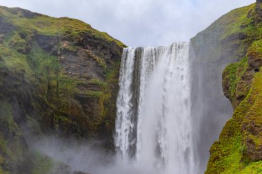 Güzel Skogafoss şelalesi. İzlanda 'nın en popüler yeri. Su güzel bir vadiden aşağı düşüyor.