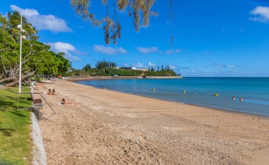 Noumea; Yeni Kaledonya: Yeni Kaledonya 'nın Noumea plajında öğleden sonra güneşinde dinlenen insanlar.