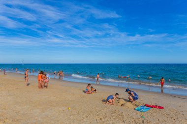 Tavira, Portekiz: Tavira adasının ünlü plajındaki insanlar. Bu plaj Algarve 'nin ünlü turistik bölgesinin bir parçasıdır..