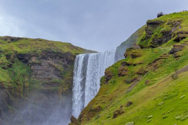 Güzel Skogafoss şelalesi. İzlanda 'nın en popüler yeri. Su güzel bir vadiden aşağı düşüyor.