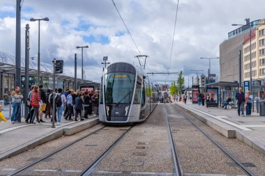 Lüksemburg şehri. Şehir merkezinde insanlarla dolu bir caddede tren durağı.