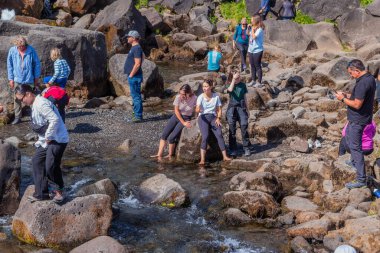 Thingvellir, İzlanda: İzlanda 'daki Oxarfoss şelalelerinde insanlar. Oxarafoss, Oxararfoss olarak da bilinir. Oxara Nehri 'ndeki Thingvellir Ulusal Parkı' nda bulunur..