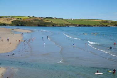 County Cork, İrlanda. İnsanlar boş zamanlarını güneşli bir yaz gününde kumlu bir plajda geçirirler. Kuzey Avrupa 'da plaj tatili. Inchydoney 'in meşhur İrlanda plajı.