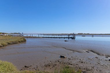 Portekiz, Lizbon 'daki Vasco da Gama köprüsü yakınlarındaki Tagus nehrinin kıyısındaki çamurluklar..