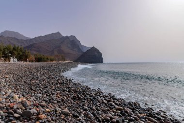 Gran Canaria, Spain: People at the black sand beach paradise in La Aldea, Gran Canaria, Canary islands, Spain clipart