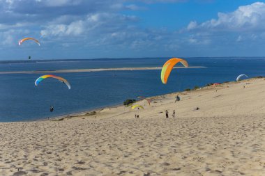 Pilat, Fransa 'nın Kumulu: Pilat, Arcachon Havzası, Nouvelle Aquitaine, Fransa' da insanlar yamaç paraşütü yapıyor.