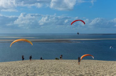 Pilat, Fransa 'nın Kumulu: Pilat, Arcachon Havzası, Nouvelle Aquitaine, Fransa' da insanlar yamaç paraşütü yapıyor.