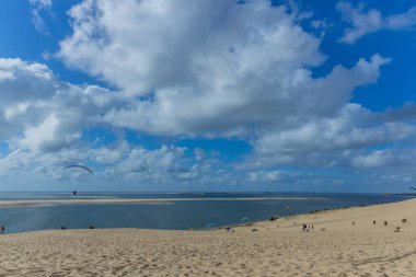 Pilat, Fransa 'nın Kumulu: Pilat, Arcachon Havzası, Nouvelle Aquitaine, Fransa' da insanlar yamaç paraşütü yapıyor.