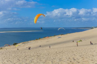 Pilat, Fransa 'nın Kumulu: Pilat, Arcachon Havzası, Nouvelle Aquitaine, Fransa' da insanlar yamaç paraşütü yapıyor.