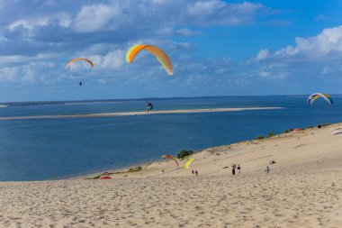 Pilat, Fransa 'nın Kumulu: Pilat, Arcachon Havzası, Nouvelle Aquitaine, Fransa' da insanlar yamaç paraşütü yapıyor.