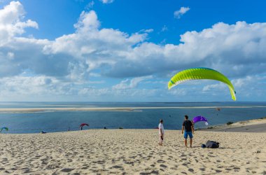 Pilat, Fransa 'nın Kumulu: Pilat, Arcachon Havzası, Nouvelle Aquitaine, Fransa' da insanlar yamaç paraşütü yapıyor.