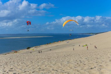 Pilat, Fransa 'nın Kumulu: Pilat, Arcachon Havzası, Nouvelle Aquitaine, Fransa' da insanlar yamaç paraşütü yapıyor.