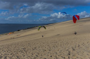 Pilat, Fransa 'nın Kumulu: Pilat, Arcachon Havzası, Nouvelle Aquitaine, Fransa' da insanlar yamaç paraşütü yapıyor.
