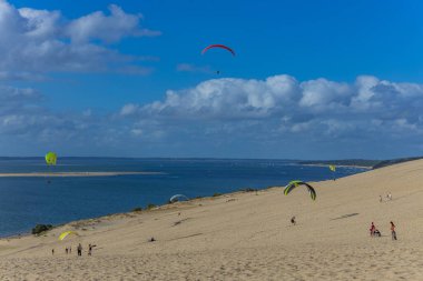 Pilat, Fransa 'nın Kumulu: Pilat, Arcachon Havzası, Nouvelle Aquitaine, Fransa' da insanlar yamaç paraşütü yapıyor.