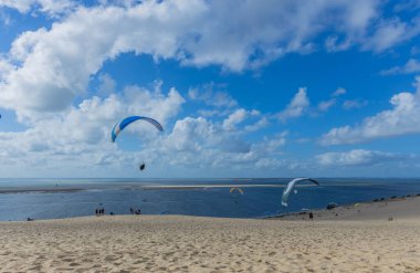 Pilat, Fransa 'nın Kumulu: Pilat, Arcachon Havzası, Nouvelle Aquitaine, Fransa' da insanlar yamaç paraşütü yapıyor.