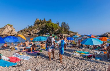 Taormina, İtalya: Arkadaki Isola Bella adası ile Taormina sahilinde yaşayan insanlar. Sicilya, İtalya