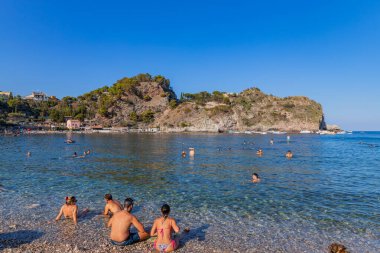 Taormina, İtalya: Arkadaki Isola Bella adası ile Taormina sahilinde yaşayan insanlar. Sicilya, İtalya