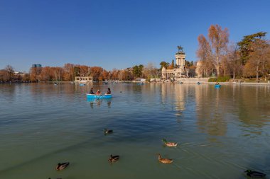 Madrid, İspanya: İnsanlar İspanya 'nın Madrid kentindeki El Retiro Parkı' nda tekne gezisinin keyfini çıkarıyorlar. El Retiro, Madrid 'in en büyük parkıdır. İspanya.