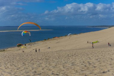 Pilat, Fransa 'nın Kumulu: Pilat, Arcachon Havzası, Nouvelle Aquitaine, Fransa' da insanlar yamaç paraşütü yapıyor.