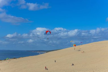 Pilat, Fransa 'nın Kumulu: Pilat, Arcachon Havzası, Nouvelle Aquitaine, Fransa' da insanlar yamaç paraşütü yapıyor.