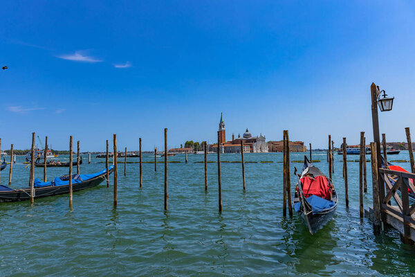 Venice, Italy: Gondolas against the San Giorgio island in Venice, Italy. Gondola is the most attractive tourist transport in Venice. Traveling and vacation in sunny Venice.