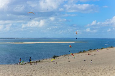 Pilat, Fransa 'nın Kumulu: Pilat, Arcachon Havzası, Nouvelle Aquitaine, Fransa' da insanlar yamaç paraşütü yapıyor.