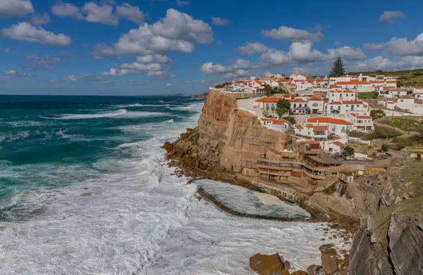 Sintra, Portekiz: Azenhas 'taki kayalıklar açık mavi gökyüzünün altında deniz köpüğüyle uçuyor.