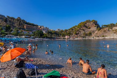 Taormina, İtalya: Arkadaki Isola Bella adası ile Taormina sahilinde yaşayan insanlar. Sicilya, İtalya
