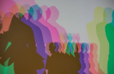 Renkli gölgeler, RGB aydınlatması boyunca duvara vurularak soyut ve sanatsal bir etkileşim yaratıyor insan siluetleri ve üst üste binen ışık.