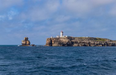 Nau dos Corvos kaya oluşumu ve Carvoeiro deniz feneri Peniche, Portekiz 'de bir uçurum üzerinde