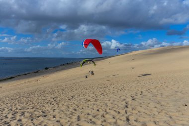 Pilat, Fransa 'nın Kumulu: Pilat, Arcachon Havzası, Nouvelle Aquitaine, Fransa' da insanlar yamaç paraşütü yapıyor.