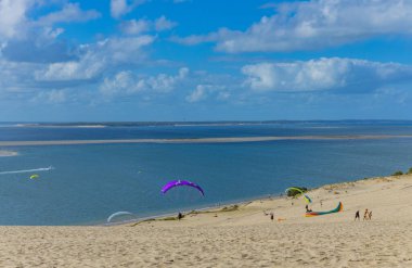 Pilat, Fransa 'nın Kumulu: Pilat, Arcachon Havzası, Nouvelle Aquitaine, Fransa' da insanlar yamaç paraşütü yapıyor.