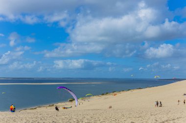 Pilat, Fransa 'nın Kumulu: Pilat, Arcachon Havzası, Nouvelle Aquitaine, Fransa' da insanlar yamaç paraşütü yapıyor.
