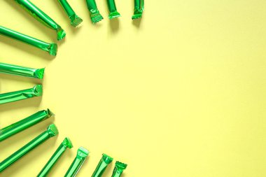 Pastel arka planda yeşil parlak boruların üst görüntüsü. Çok fonksiyonlu arkaplan.