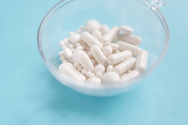 Mavi masaya saçılmış beyaz haplar. Reklam, web geçmişi ya da diğer fikirler için özel teklifler alın. Tıbbi, eczane ve sağlık hizmetleri konsepti. Uzayı kopyala Metin veya logo için boş yer