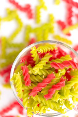 Fusille ve Rotini 'nin arka planında beyaz cam bir kase içinde. makarna kolorata