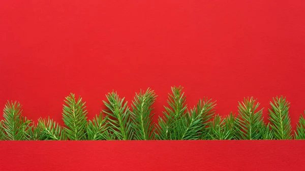 Weihnachtsrahmen Aus Weihnachtsbaumzweigen Mit Bokeh Lichtern Auf Schlichtem Papierrotem Hintergrund — Stockfoto