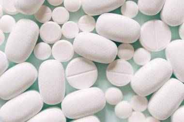 Mavi masaya saçılmış beyaz haplar. Reklam, web geçmişi ya da diğer fikirler için özel teklifler alın. Tıbbi, eczane ve sağlık hizmetleri konsepti. Uzayı kopyala Metin veya logo için boş yer